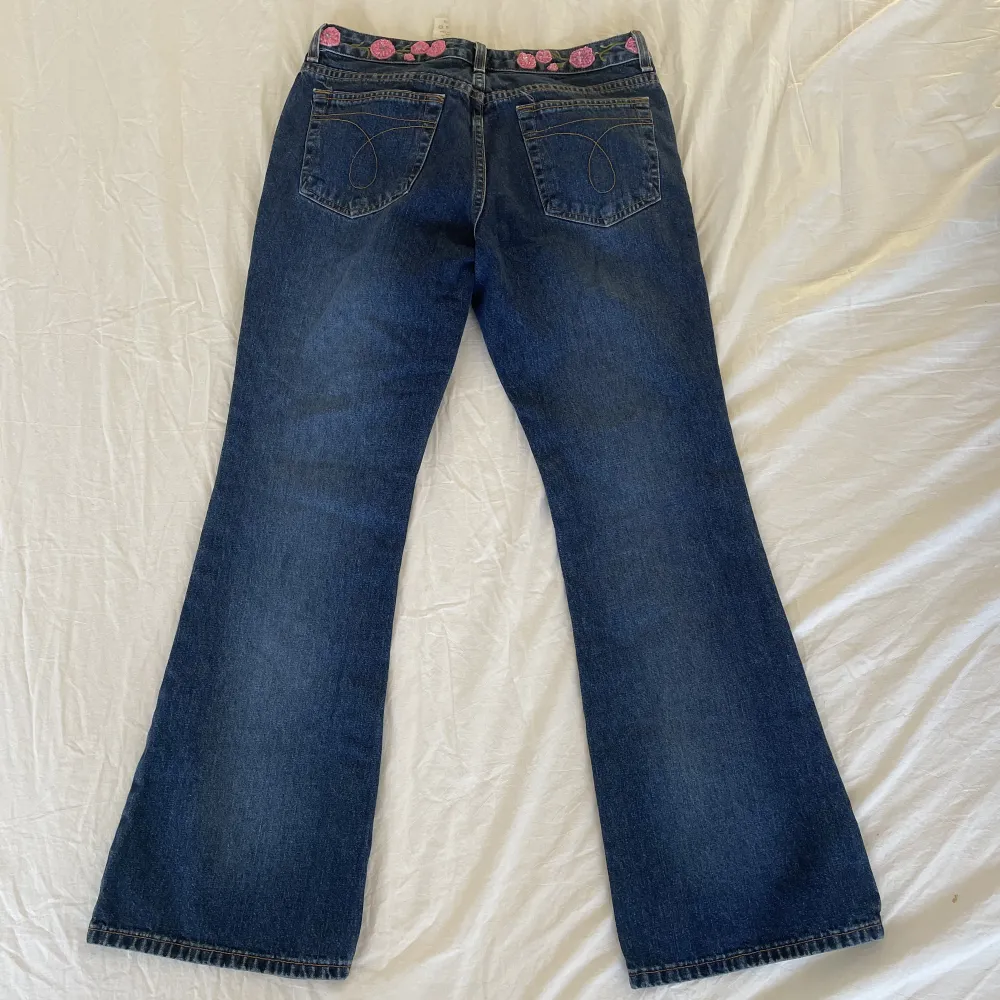 Supersöta jeans med blommor på, i väldigt gott skick🐷 Midjemått:76 cm  Längd:98 cm Innerbensmått:72 cm. Jeans & Byxor.
