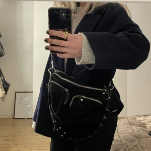 Svart väska - Säljer min svarta väska från Gina! Knappt använd och är i nyskick. Kommer med ett långt band och ett kort med nitar på❤️‍🔥