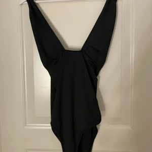 Svart body  - En svart body som är korsad runt axlarna, aldrig använd då de inte är min stil 