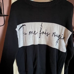 Stickad tröja  - Grå Stickad tröja med ett franskt citat på, från NAKD med Misslisibells kollektion. I storlek S, använd fåtal gånger men i ny skick fortfarande. Jätteskönt material som passar till svala sommarkvällar 💗