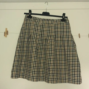 Rutig kjol - Fin rutig kjol, ganska kort men inte så kort. Räcker till några cm över knäna på mig (172cm).   Står stl 34 men passar 36-38 med skulle jag påstå. Dragkedja i sidan. Har små ”öglor” (vad heter det?) för skärp. 