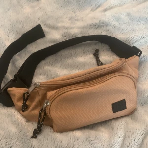 Midjeväska - Lager 157 - En beige/brun midjeväska från Lager 157. Använt en-två gånger, och är i väldigt bra skick. Säljer pga att den inte var i min stil. Köpare står för frakten🫶