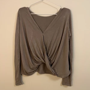 Vintage tröja fr Tessie - Många år gammal tröja men bevarad i bra skick trots åldern. Från den gamla populära butiken Tessie i Göteborg. Den tvistade delen kan sitta antingen bak eller fram. Färgen är ljusbrun/grå med lite stentvättad look. 