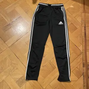 Begagnade Adidas träningsbyxor/träningstajts storlek 164. Använda byxor dock i gott skick. Dragkedja längst ut på båda byxbenen. 