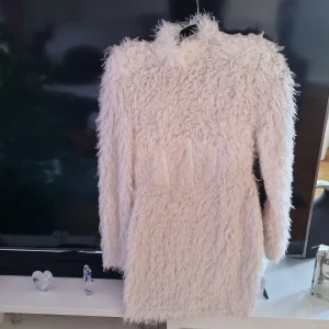 Klänning  - Fin vit pälsig klänning strl 38 aldrig använd då den blev liten,har lång dragkedja bak,köpt för 5mån sen,passar till en smal tjej.