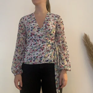 Blommig blus - Förgglad blommig blus Använd men inga spår på sliten. Skön och fin till sommaren då den är luftig och färgglad. Passar väldigt fint till ljus jeanskjol