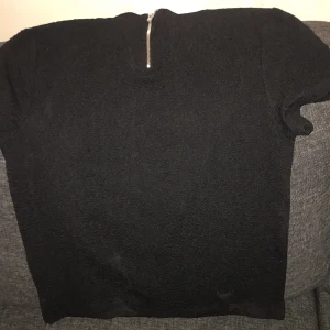 T-shirt - Liten polokrage. Dragkedja i nacken. Mönstrad 