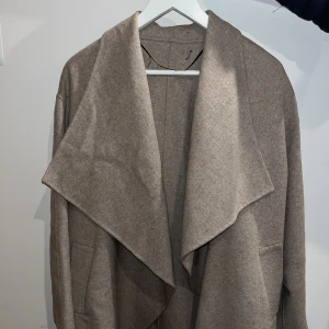 Beige kappa  - Mysigaste kappan! Lite cape-liknande då den inte har några knappar och lite trekvarts-ärmar. Sååå skön att kasta över typ vilken outfit som helst! 