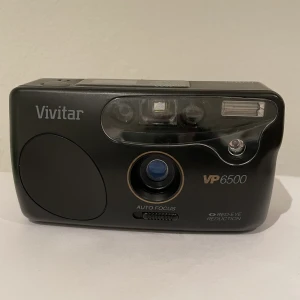 Vivitar VP 6500 - Film kamera i fint skick, inga synliga skador. Testad med batteri och allt verkar funka som det ska. kameran använder sig av film såsom kodak, fuiji film. Ej funktionstestad med film