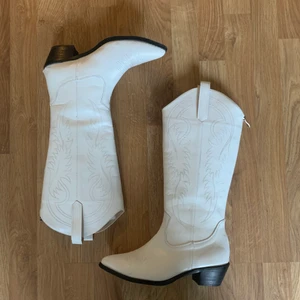Vita cowboy boots  - Så fina vita cowboy boots! Praktiskt dragkedja baktill. Väldigt sköna att gå i, använda 1 gång. Passar mig bra som har 39/40 i storlek vanligtvis. 🤠