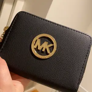 En svart extra fin och bra plånbok, inte använd en endaste gång!! Den är dessutom i märket MK! Bra kvalite och säljer den bara för 150 kr!!!👍🌸