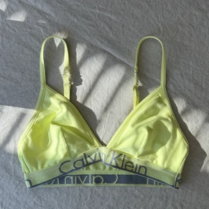 Calvin Klein Topp - En ljus neon gul Calvin Klein topp, säljs pga liten storlek, st; S/XS eller A-B cupa. Den är helt oanvänd, har bara testat den 1 gång.