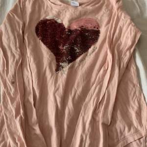 En rosa tröja som man kan ändra färg på bröstet. Säljer då det inte är min stil.