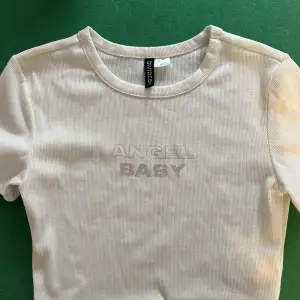 En fin vit topp med ”angel baby” tryck på framsidan!  Skickas tvättad!