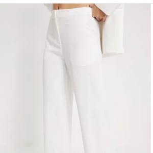 Vita raka kostymbyxor  - Vita raka kostymbyxor från Nelly, använda 1 gång på min kusins student. Som nya inga fläckar eller så.Skriv för fler bilder eller frågor. Nypris:500kr kommer sälja för 200kr kan sänkas till 150kr