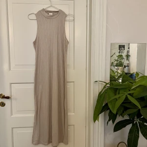 Beige klänning🤍 - Randig beige/champagne klänning med slitsar på båda sidorna. Till vaderna på mig som är 160cm. Lite genomskinlig. Från H&M, storlek M. Bara provad. Kan mötas i Göteborg eller skicka, köparen står för frakt. 