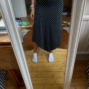 Svart prickig långkjol  - Tunn fin långkjol med vitprickigt mönster 