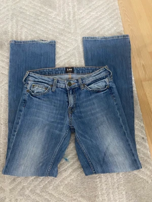 Lee jeans - Skit snygga lee jeans i stl 32/34 skulle jag säga Lågmidjade mä bootcut. Dom är för små på mig så kan it skicka några bilder på. Lite små slitna vid hälen men d ä inget man tänker på. Skriv för fler bilder. Midjemått rakt över (36cm) innerbenslängd (78cm)
