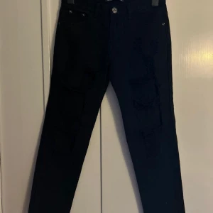 Helt nya svarta denim jeans med slitningar  - Av märket. Top trends. We're denim wear