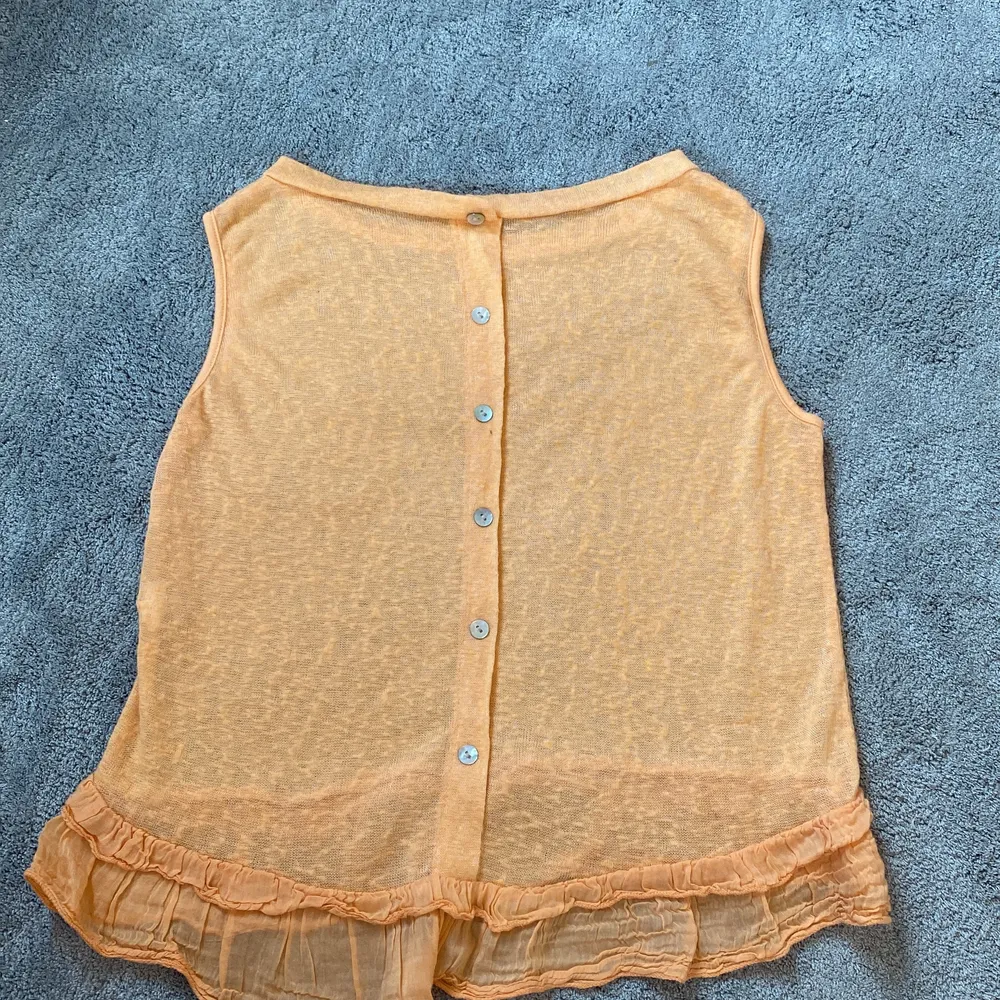 Ett orange linne från J&L i bra skick med en liten volang nertill i stolek s/xs. Blusar.