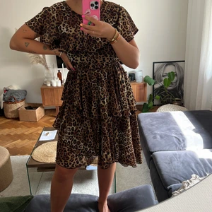Leopard klänning - En klänning i leopard mönster från NA-KD! Assymetrisk form, lite längre på ena sidan! Strl 36. Använd fåtal gånger och i superfint skick, dock har tråden man fäster knappen med i nacken släppt men det är lätt fixat! ✨⭐️