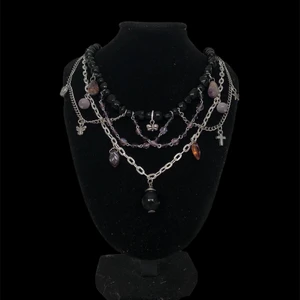 Handgjort halsband  - Ett svart och lila halsband med lite olika berlocker. Halsbandet är justerbart och det är fri frakt! 