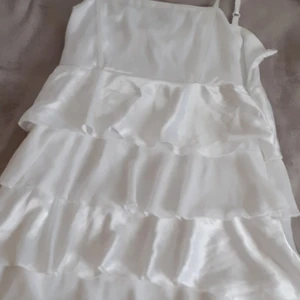 Vit volang-klänning storlek S - En spuerfin klänning i siden! Bara använd under 1 dag. INTE genomskinlig alls eftersom att den har sidenvolanger som ett extra lager! 299kr + frakt (39 kr) Nypris: 450kr.   Skriv om du budar eller vill köpa direkt för 400 kr. Avslutas 7/8-22