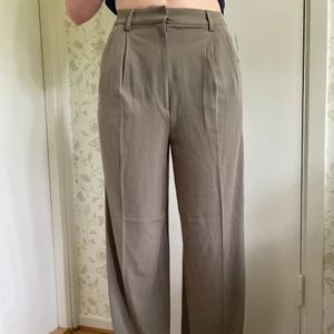Beiga Kostymbyxor  - Snygga beige/gråa kostymbyxor från HM. Byxorna är i storlek 38 och säljer för 80kr + frakt🫶🏼