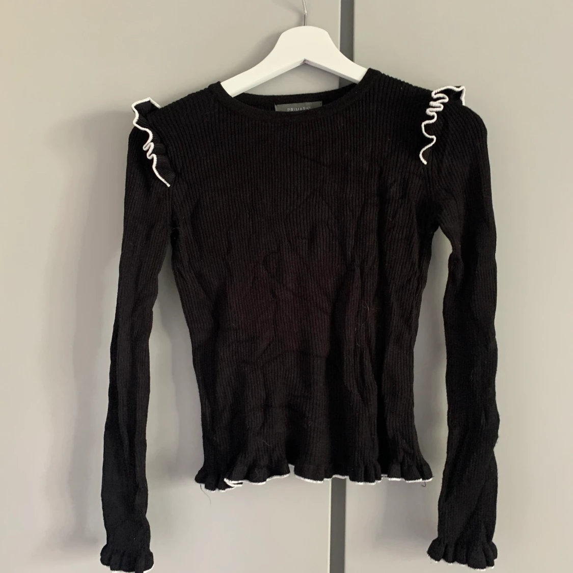 Svart volangtröja med vit kant