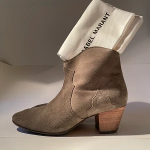 Isabell Marant Dicker Boots 38 - Isabel Marant ”Dicker” boots. Ankelhöga beiga boots i beige mocka m dragkedja vid sidan.  Begagnade, men inget hårt slitage utan bootsen har mer att ge! Kartong och dustbag ingår.  Storlek 38  Nypris över 4000kr.   Hemmet är rök- och djurfritt.