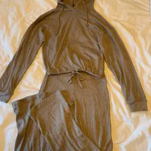 Ett brun beiget sett från bikbok byxorna i storlek xxs och tröja i storlek xs  Tröjan har prislappen på 