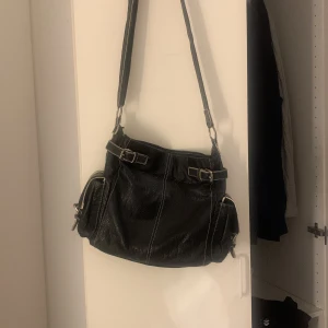 läder/skinn väska - jätte cool och rymlig väska. Justerbaras band och mycke små fack, aldrig använd