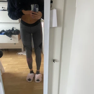 Träningstights adidas  - Supersnygga Gråa lågmidjade träningstights från adidas storlek S, med ett rosa märke på ena benet! Använda fåtal gånger! 💕