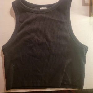 Svart basic - Andänd max 2 gånger, H&M basic. Bra kvalitet. Snygg. Köpt för två årsedan. Croptop. Inga fläckar.