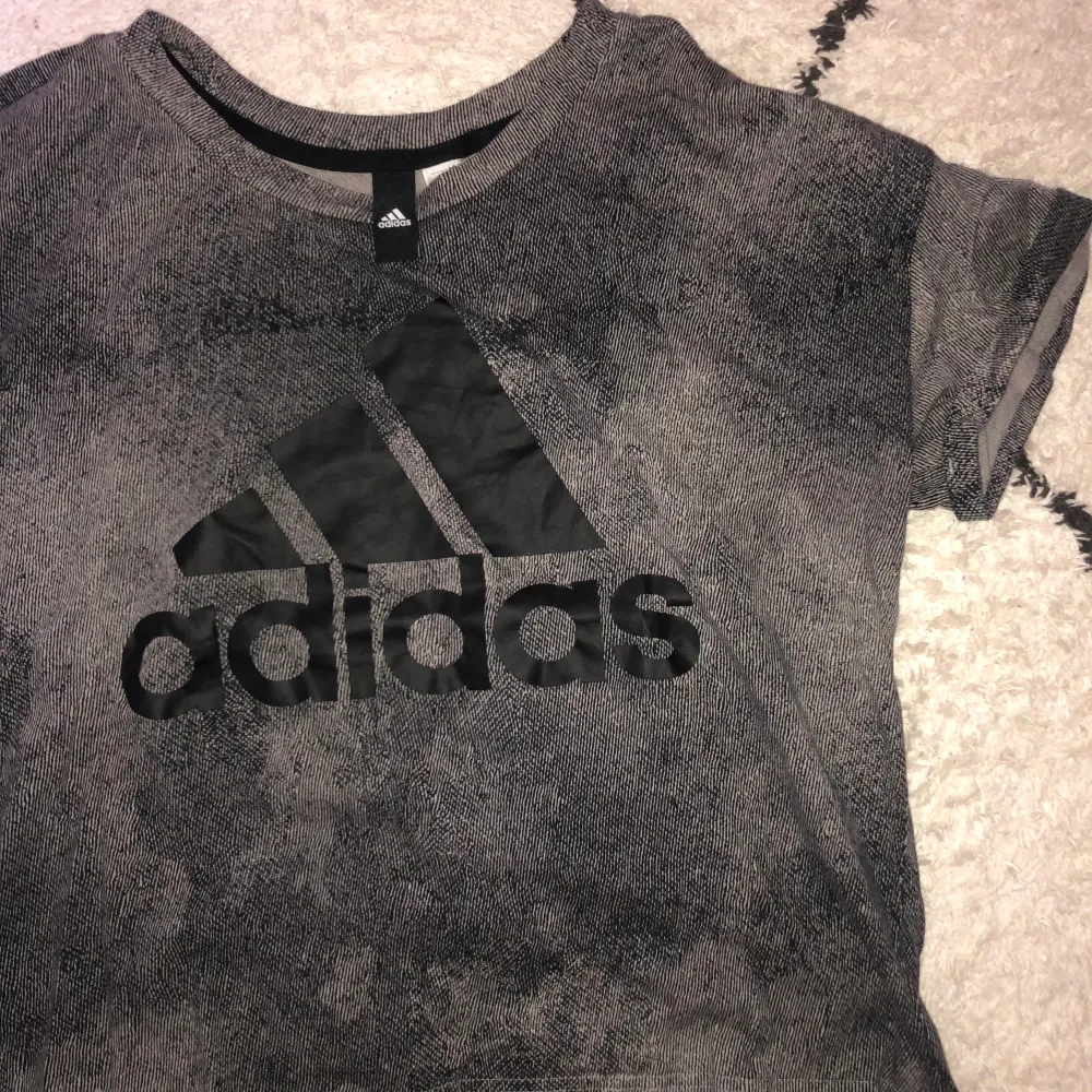 Adidas t-shirt, grå/svart med ett svart adidasmärke. Oanvänd, bra skick!. T-shirts.