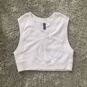 Croppad tröj-väst från HM i strl xs - Det här är en croppad vit väst i bra skick! Använ ca 2 gånger. Mjukt och gosigt material inuti!🫶🏼