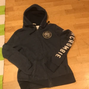 En hoddies  - En blå hoddie med dragkedja  och broderade i arm med . 