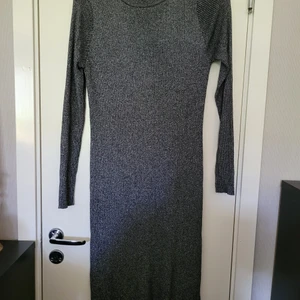 Klänning - Silverglittrig klänning med lång ärm. Går till knäna. Använd enstaka gånger. Storlek L men funkar för M också.  Från djur och rökfritt hem  Kan skickas mot fraktkostnad 