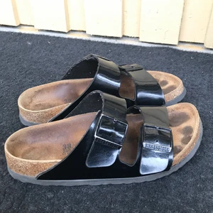 Glansiga birken - Ett par glansiga svarta birkenstock i strl 38. Använda under en sommar❣️
