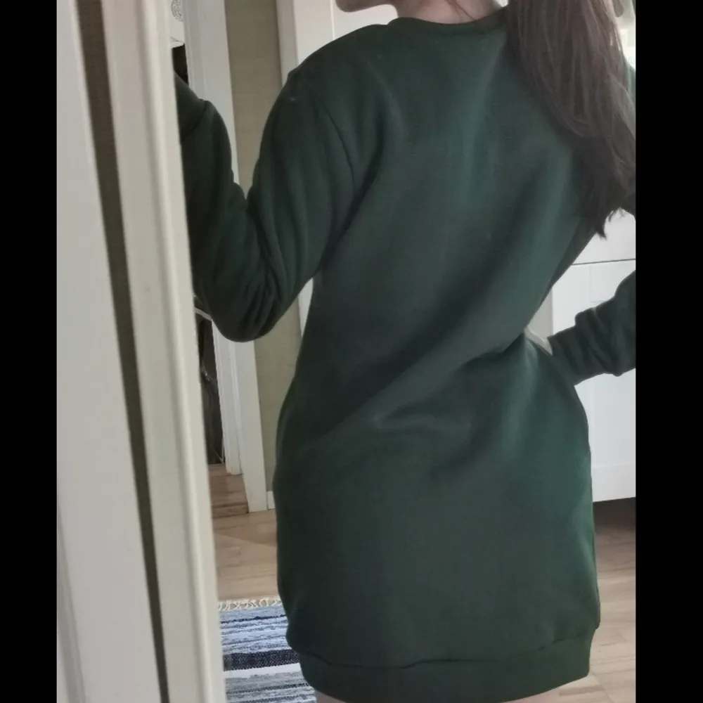 En mörk grön lång tröja som kan också användas som klänning. Det här ett tjockt och varmt tyg som är väldigt skönt. Jag är 1.60 och därför kan det ses längre på mig. . Hoodies.