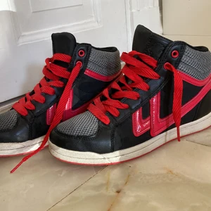 Coola skor  - Svarta skor med röda detaljer i storlek 38 i väldigt fint skick.  Frakt tillkommer Hör av dig vid intresse!!  