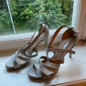 Glittriga klackskor stl 39  - Säljer dessa fina silvriga klackskor köpta i Paris för ett bröllop. De är endast använda ett tillfälle, så i mycket bra skick. Märket tyvärr okänt. Storlek 39 