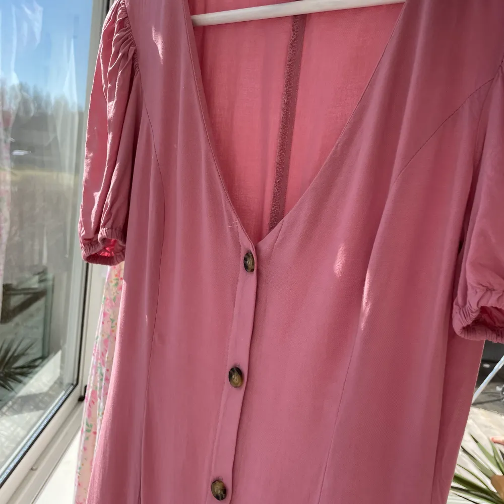 Rosa klänning från H&M med knappar och puffärmar. . Klänningar.
