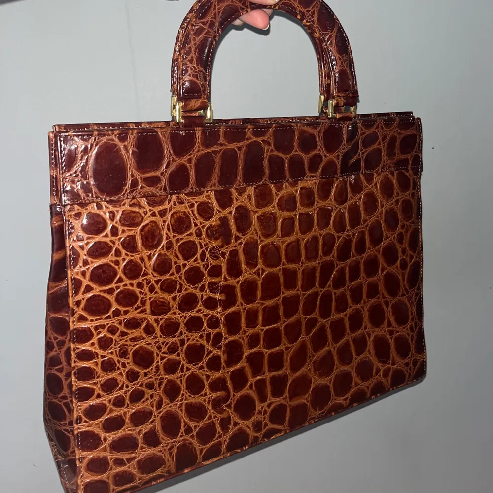 Super fin brun handväska med guldiga detaljer! Köpt second hand men i jättebra skick, är i lite större modell och väldigt praktisk samt snygg💓💓 skriv om du har frågor🥰. Väskor.