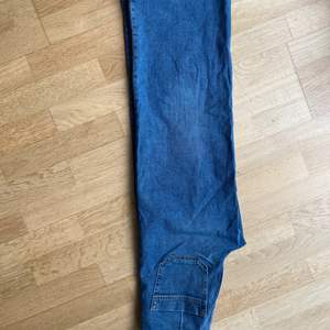 Jeans ”Culotte” med hög midja och raka, vida ben, från HM. Mellanblå med fickor fram och bak, dragkedja, knapp. 99% bomull och 1% elastan. Bra skick.