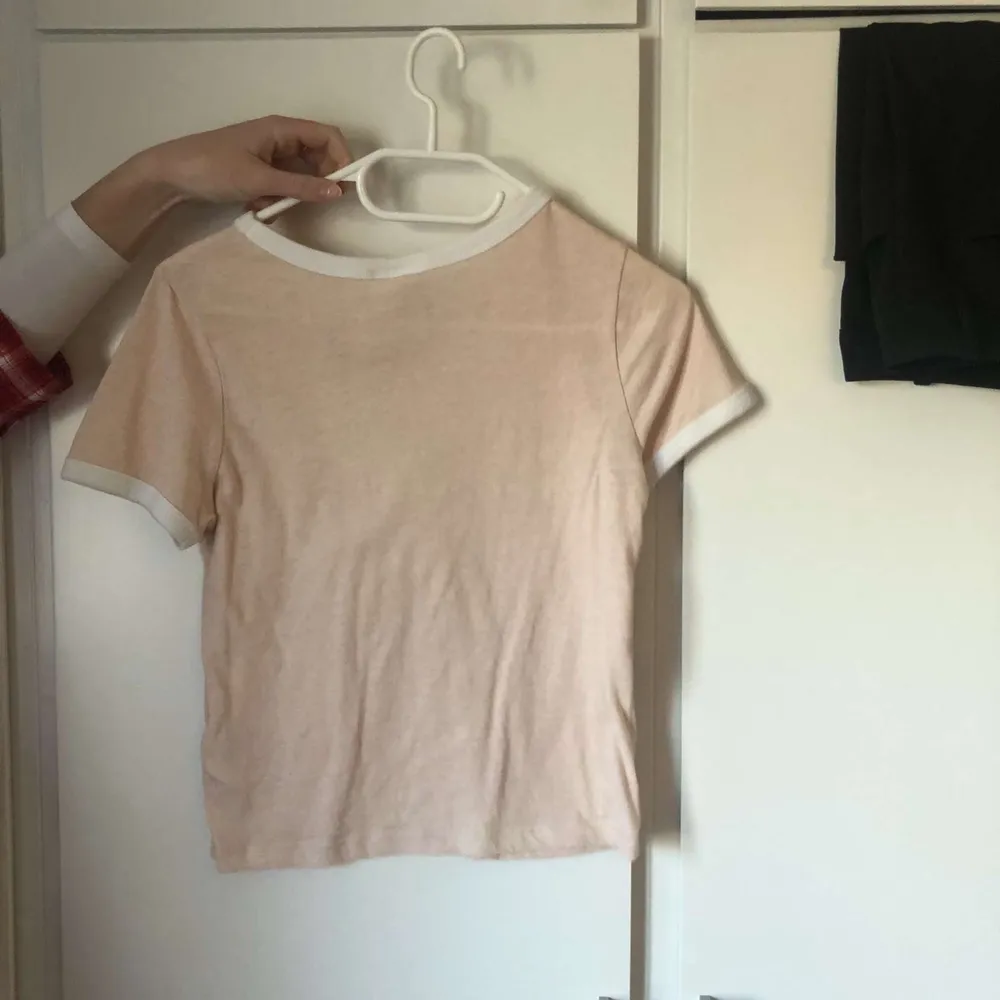 Ljusrosa T-shirt från hm med vita detaljer. Använd fåtal gånger så inget fel på den!❤️. T-shirts.