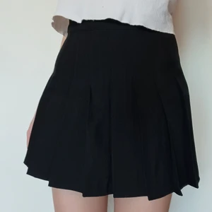 Svart tenniskjol  - Svart minikjol stl XS med inbyggda safety shorts. Mycket bra skick, använt ett fåtal gånger. 