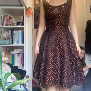 Vintage svart/orange klänning  - Vintage klänning, inte säker från vilket årtal. Har en underkjol  och är i hyfsat skick, kontakta för frågor om passform 