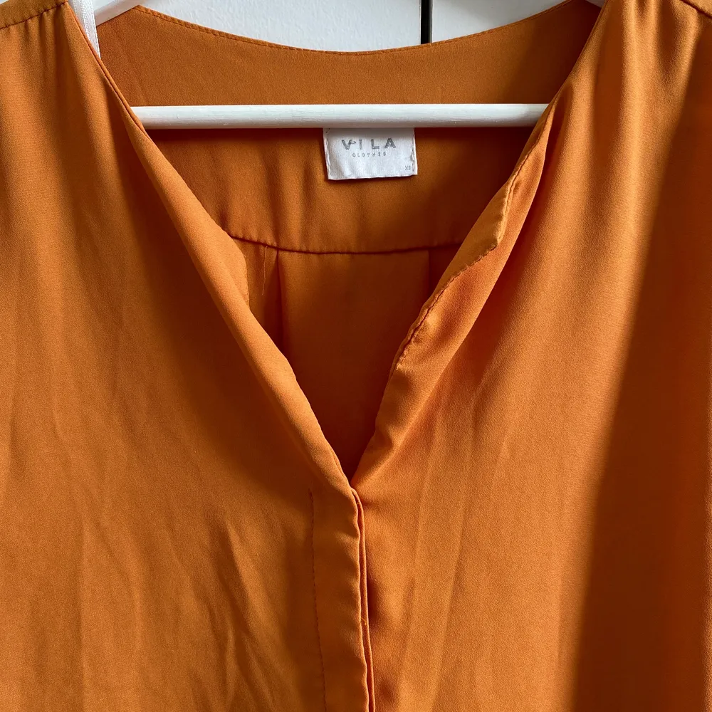 Tunn skjorta i härligt orange. Dolda knappar. Ej genomskinlig. Stor i storlek.. Skjortor.