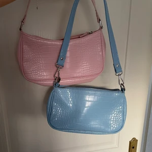 Blå handväska  - Jättefin blå handväska från Gina tricot. Köpt förra sommaren men endast använd ett fåtal gånger och ser därav fortfarande ut som ny. Köpt för 300kr, säljer nu för 149kr. Krokodiltextur (ej riktigt). Avtagbart axelband. Passar jättefint till en vår- eller sommaroutfit. 